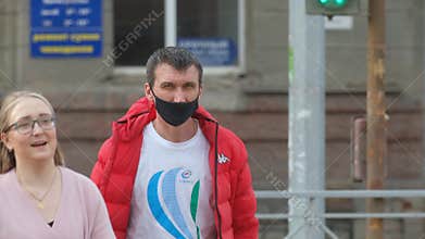 Masked people are walking in America. American man in coronavirus. Covid-19.