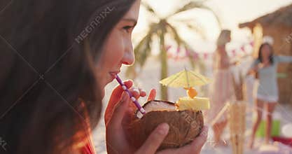 Caucasian woman drinking a cocktail on the beach