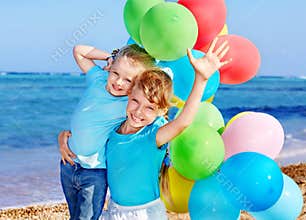 Children playing with balloons at the beach