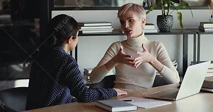 Confident professional female mentor training employee in office