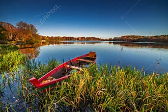 Red boat, lake landscape in fall season