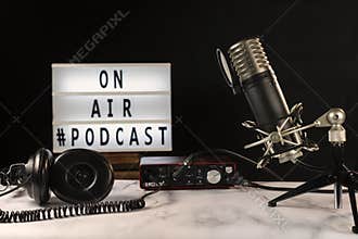 Podcast studio set with microphone, headphones, console and on air sign turned on,