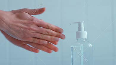 Unrecognizable woman applying sanitizing gel or liquid rubbing hands.