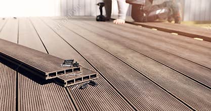 Wpc terrace construction - worker installing wood plastic composite decking boards