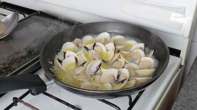 Chef presenting delicious clams in olive oil, garlic and chop onions