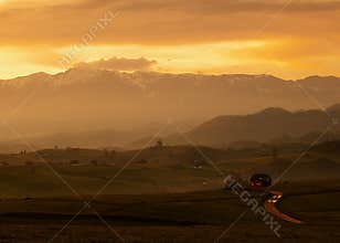 Scenic Hills In Beautiful Sunrise With Traditional Old House and Road