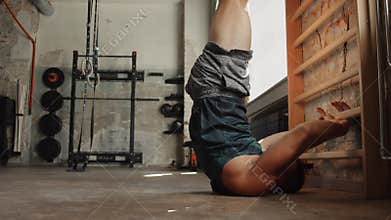 Man exercising at gymnastics wall bars in gym