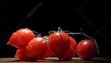 4k. Cherry tomatoes close-up. Rotating red Cherry tomatoes jn black background with water drops. Red Cherry Tomato Clockwise.