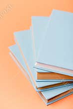 Focus of stack of blue books on orange surface