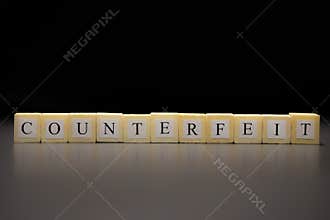 The word COUNTERFEIT written on wooden cubes isolated on a black background
