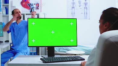 Doctor working on computer with green screen