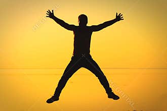A man in a free jump against the sunset.