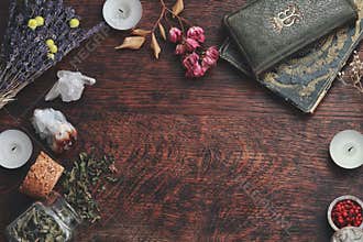 Dark brown wooden table background for text, decorated with witchy wiccan items to look esoteric and occult