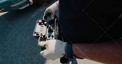 Belarus, Minsk - July 30, 2020: Close-up of a mobile crane radio remote control panel in the hands of a crane operator.