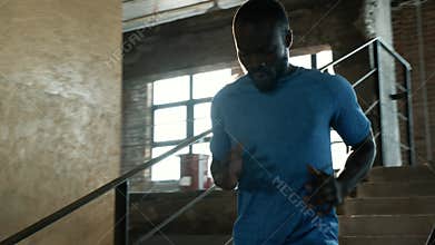 Workout. Runner man running down stairs, training indoors