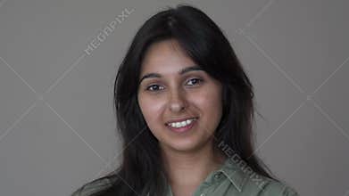 Confident smiling indian business woman look at camera on brown background.