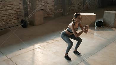 Fitness workout. Sport woman doing squat leg exercise at gym