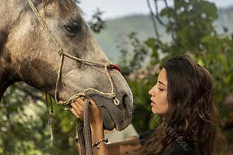 Covid 2020 summer. A young girl is preparing to ride her horse.