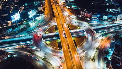 Hyper lapse time-lapse of car traffic transportation above circle roundabout road in Asian city. Drone aerial view fly in circle