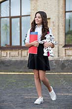 My school is fun. Happy child hold books and toy outdoors. Back to school supplies. Formal fashion. Primary education