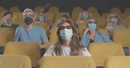 People in face masks watching 3d film in cinema on coronavirus quarantine. Portrait of men and women in movie theater on