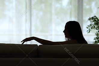 Sad woman missing her partner sitting alone at home