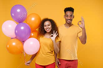 Funny friends couple african american guy girl in casual clothes isolated on yellow background. Birthday holiday party