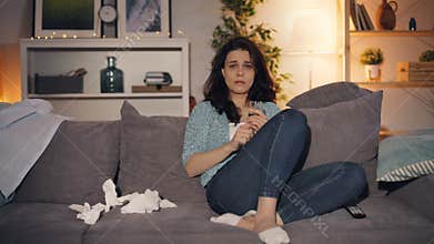 Upset woman drinking alcohol crying watching sad movie on TV at home alone