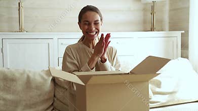 Excited young woman consumer open cardboard box get postal parcel