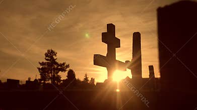 Death life concept. cemetery crosses sunlight glints from behind the graves at sunset cross silhouette lifestyle