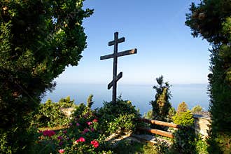 Huge wooden Orthodox eight-pointed cross against the sky after the dawn on Mount Athos