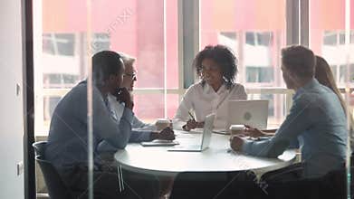 Different ages and ethnicity businesspeople gathered in boardroom for negotiating