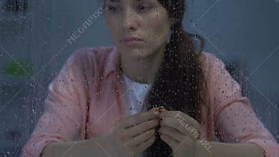 Frustrated female holding engagement ring, suffering after painful breakup