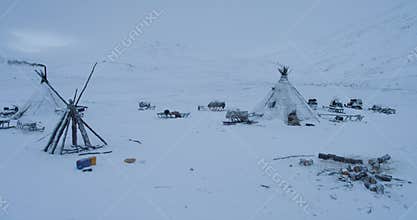 Drone capturing the yurts closeup in the evening in middle of Arctic , many sleigh outside the yurts.