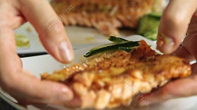 Woman food styling and cooking salmon fish with rice and cucumber