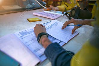 Construction coal miner supervisor conducting safety checking on job hazards analysis on hot work permit before sign off