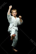 A little boy in a white kimono fulfills blows