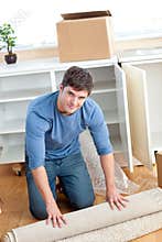 Cute man rolling a carpet out