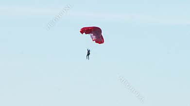 A detachment of military soldiers paratroopers landed to complete the mission on the background of blue sky