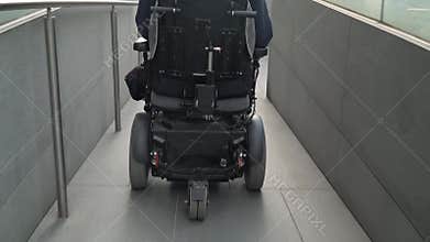 4k resolution back view of a man on electric wheelchair using a ramp. Accessibility concept