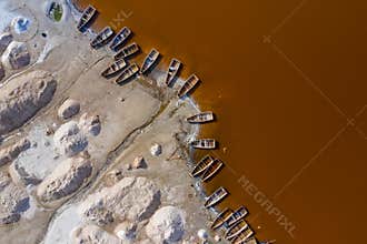 Aerial view of the small boats for salt collecting at pink Lake Retba or Lac Rose in Senegal. Photo made by drone from above.