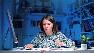 A criminalist in police sitting at a table working at a computer.
