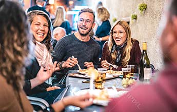 Young friends having fun drinking white wine at street food festival - Happy people eating local plates at open air restaurant