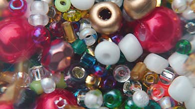 The jeweler pours multicolored beads into a bag.