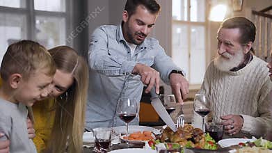 Close up of pleasant cheerful different generation relatives which watching for cutting roast turkey during family