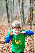 Sily six year old boy holding out six fingers