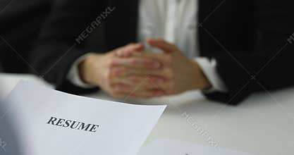 Hiring manager interviews a woman in a job interview reviewing resume
