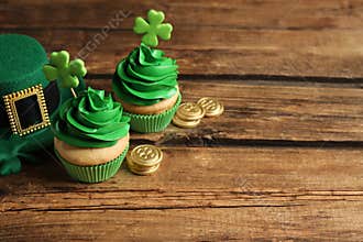 Composition with decorated cupcakes on wooden table, space for text. St. Patrick`s Day celebration