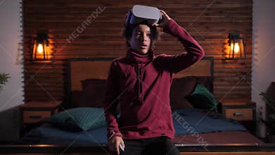 Mixed race boy taking off VR glasses during game