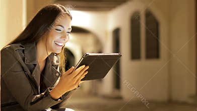 Woman browsing tablet content in the night